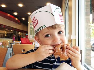 child eating a Krispy Kreme doughnut